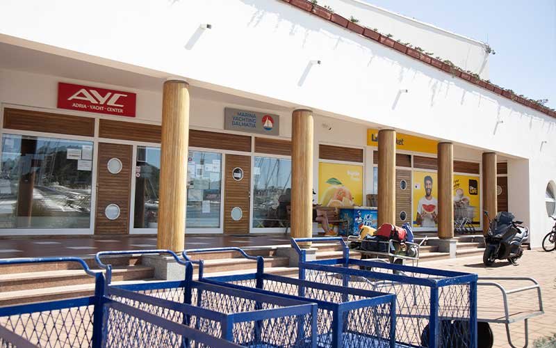 The marina buildings with various shops, creating a lively waterfront atmosphere