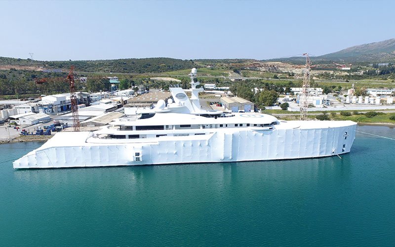 Close aerial view of Chalkis Shipyards with cruise ships, superyachts, and commercial vessels in dry dock and alongside the quay for repair, refit, and maintenance services.