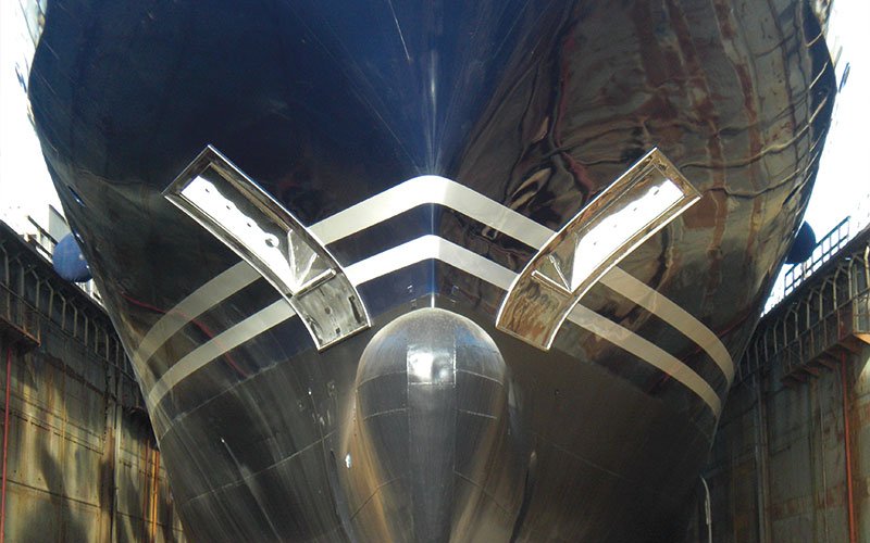 Close aerial view of Chalkis Shipyards with cruise ships, superyachts, and commercial vessels in dry dock and alongside the quay for repair, refit, and maintenance services.