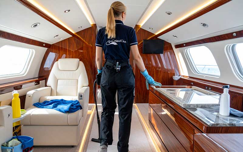 Crystal Clean professional disinfecting yacht kitchen area with marine‑safe cleaning supplies.