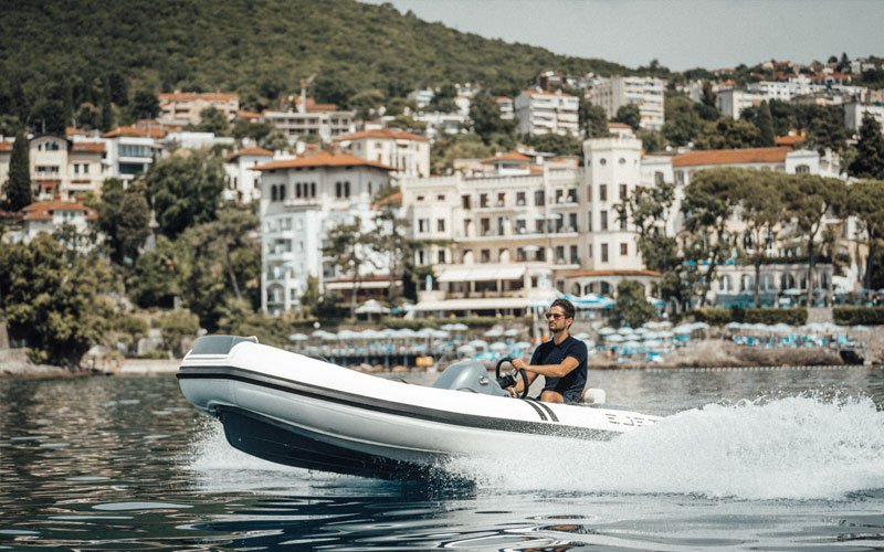 Man driving a jet-powered inflatable boat on the water