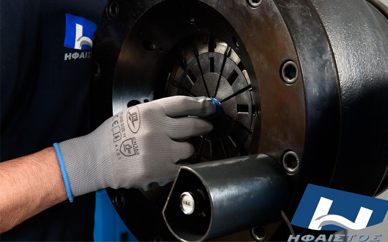 Skilled technician operating industrial CNC clamping system at General Constructions Ifaistus metalworking facility