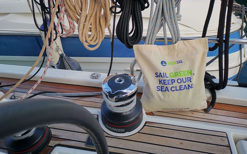 Sailing boat, deck with rings and ropes, a bag with the logo of rgeen sail.