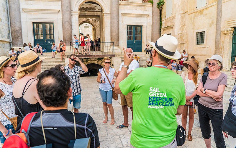 A men from the team of Green Sail, talking to people at the street.