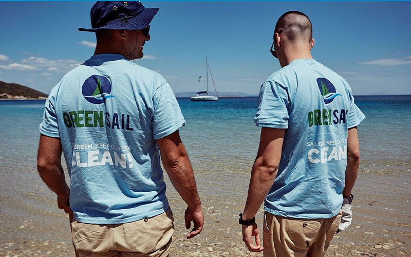 Two men at the sea wearing the t-shirt of Green Sail