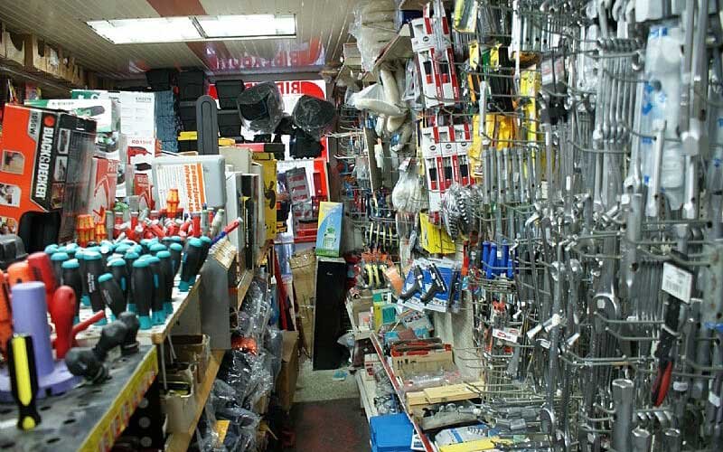 Interior view of the LIANOS NIKOLAOS hardware section showcasing an extensive assortment of hand tools such as pliers, wrenches, hammers, wire cutters, and measuring tools, all organized on a pegboard wall display.