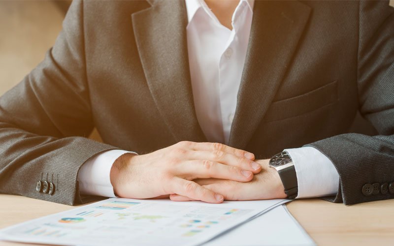 business man in suit, sitting at desk with business documents