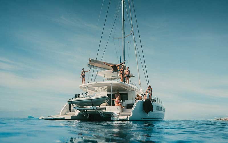 Luxury catamaran sailing experience with More Sailing in crystal clear Mediterranean waters, featuring relaxed guests on board, gourmet dining, and unforgettable sea views.