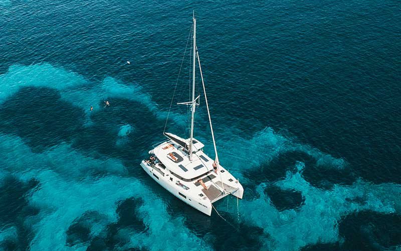 Luxury catamaran sailing experience with More Sailing in crystal clear Mediterranean waters, featuring relaxed guests on board, gourmet dining, and unforgettable sea views.