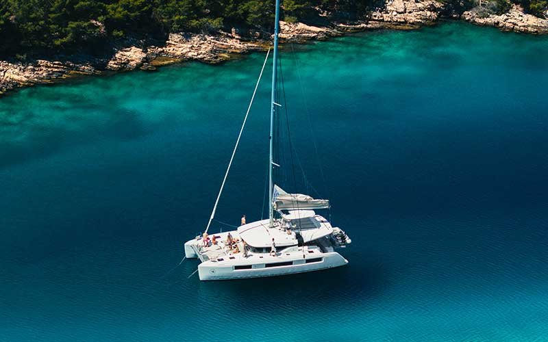 Luxury catamaran sailing experience with More Sailing in crystal clear Mediterranean waters, featuring relaxed guests on board, gourmet dining, and unforgettable sea views.
