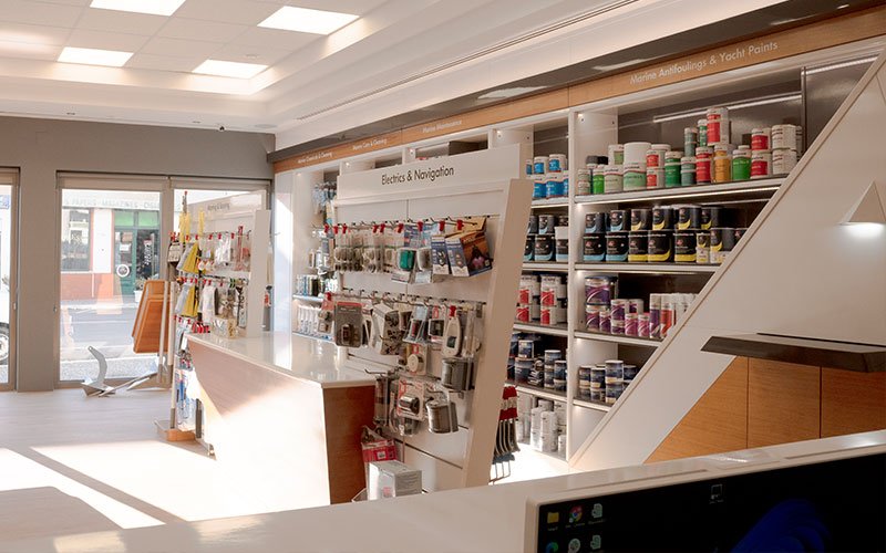 Interior view of Naval Store Yacht Supplies by Artemis Leros Boatyard, featuring light wood furniture and various products on display