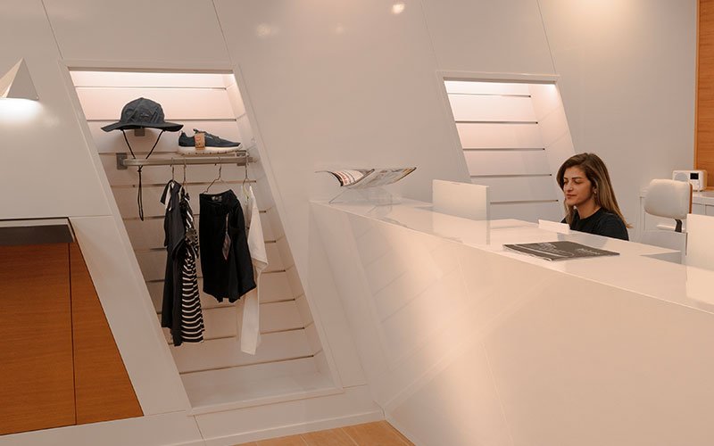 Interior view of Naval Store Yacht Supplies by Artemis Leros Boatyard, featuring light wood furniture and various products on display
