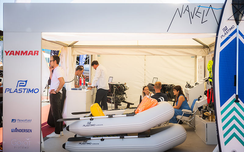 NAVELA exhibition booth featuring an inflatable boat and marine safety equipment.