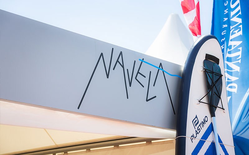 NAVELA logo displayed on the company's exhibition stand at a marine trade show.