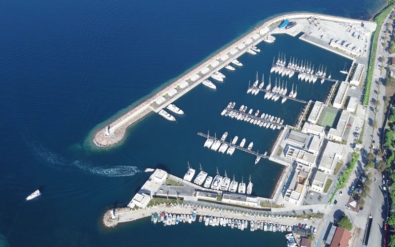 Top View of Oasis Marina Yeni Foca. A yacht leave the marina and others lined up!