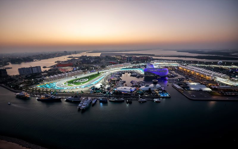Aerial sunset view of Yas Marina Circuit winding around the waterfront and marina.