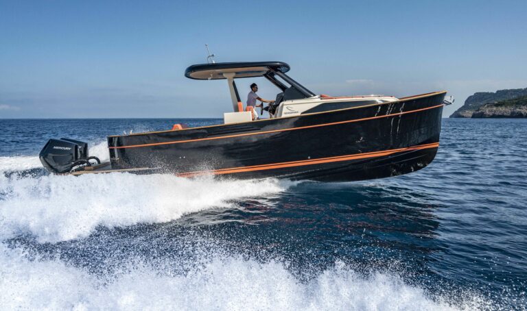 The highly anticipated 2023 Cannes Yachting Festival, which will take place from the 12th to the 17th of September, will host the world debut of the latest and most innovative version of the iconic Gozzo range from the Apreamare boatyard: Gozzo 35 Speedster. This model, powered by two powerful Mercury V10 engines of 400 horsepower each, offers performance worthy of a true fast cruiser, boasting a top speed well in excess of 40 knots. It’s an unexpected combination of the timeless elegance from the Sorrentine gozzo’s traditional lines with high performance, speed and great handling. Conceived with vision and courage by Cataldo Aprea, together with Marco Casali of Too Design – penning the exterior and interior lines – and Umberto Tagliavini of Marine Design who developed the hull geometry, the new Gozzo 35 Speedster borns with an unmistakable Mediterranean soul and sober, elegant lines. The innovative propulsion option appeals to those who prefer the power, lightness and practicality of outboard engines without compromising the style and space on board that are typical of Apreamare. The outboard engine makes it possible to have an even more spacious layout, in particular, a vast storage area which takes the place of the engine room to house more water toys a/o other equipments. The beach platform has been lengthened to maintain its original, legendary breadth and comfort, and is as well designed to preserve the authentic line of the gozzo. The large space allows guests to bathe comfortably, getting in and out of the water with ease and in total safety. Apreamare Gozzo 35 Speedster, despite his LOA of 11.11 meters, fits into the “under 10 meters” category, yet boasts generous spaces on and below deck. At the stern, we find a large and comfortable sun-pad plus a foldable table, ideal for up to ten guests. The side walkways of this boat are wide and safe thanks to its beam of 3.70 meters and at the bow there is another vast sun-pad completed by a social-seating area with breathtaking view while cruising. Shelter from the sun is guaranteed by a T-Top, at the base of which a wet-bar can be equipped with a sink, hob or barbecue, fridge and ice-maker. The lower deck features a spacious cabin with a large double bed located forward, wardrobes and furniture with leather-covered inserts, as well as a bathroom featuring a generous separate full-height shower. The interior design takes up the lively and warm coral color in some of the fabrics and details, offering the charming atmosphere of Mediterranean landscapes, and the shipyard offers as well the owners the possibility of fully customizing leathers, fabrics and essences of wood according to any taste. The distinctive features of this new model –designed especially for a younger and more dynamic audience, keen to embody the “speedster” spirit without giving up the quality and elegance of the Apreamare brand – certainly include the sportiness and speed of the outboard engines which, moreover, reduce the weight, simplify maintenance and reduce costs compared to the version with inboard engines. At the Cannes Yachting Festival, the first model will be presented in a muscular yet elegant black livery with coral inserts, waterline and upholstery that enhance the beauty of the lines while defining its bolder character
